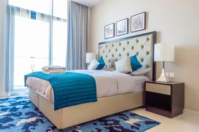a bedroom with a large bed with a blue blanket at Luxury Escapes - Quiet Studio near Expo City and DWC Airport - CELESTIA TOWER in Dubai