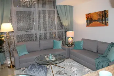 a living room with a couch and a table at Newly furnished One Bedroom Apartment next to Metro & Beach in Marina Residence in Dubai