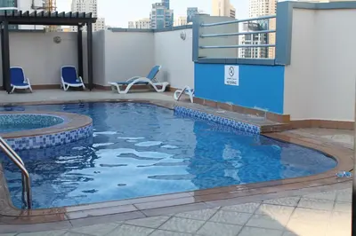 a swimming pool on the roof of a building at Newly furnished One Bedroom Apartment next to Metro & Beach in Marina Residence in Dubai