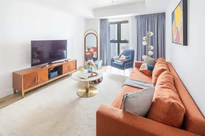 a living room with a couch and a tv at Frank Porter - Princess Tower in Dubai