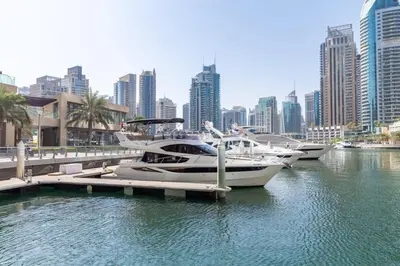 three boats are docked at a dock in a city at Frank Porter - Princess Tower in Dubai