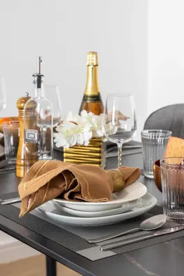 a black table with a plate and wine bottles at Frank Porter - Princess Tower in Dubai