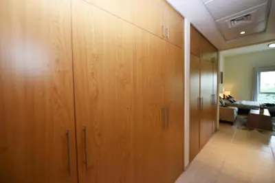 a hallway with wooden cabinets in a room at Luxury Escapes - Stylish Studio Vacation Home near Metro - MOG189 DG in Dubai