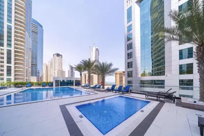 a large swimming pool in a city with tall buildings at DH58 - High end 1BR, Palm views in Damac Heights tower in Dubai
