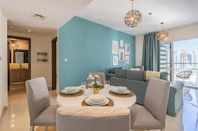 a dining room and living room with a table and chairs at Stylish Waterfront Apartment With Views on Canal in Dubai