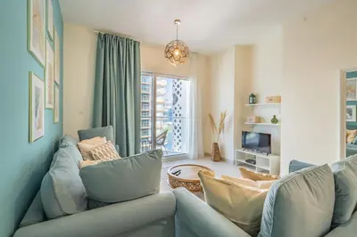 a living room with a couch and a tv at Stylish Waterfront Apartment With Views on Canal in Dubai