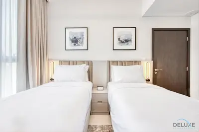 two beds in a hotel room next to a window at Elegant 2BR at Downtown Views Downtown Dubai by Deluxe Holiday Homes in Dubai