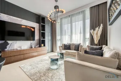 a living room with a couch and a tv at Elegant 2BR at Downtown Views Downtown Dubai by Deluxe Holiday Homes in Dubai