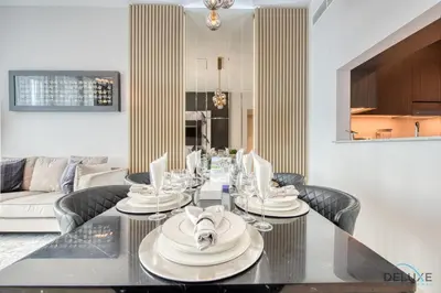 a dining room and living room with a table and chairs at Elegant 2BR at Downtown Views Downtown Dubai by Deluxe Holiday Homes in Dubai