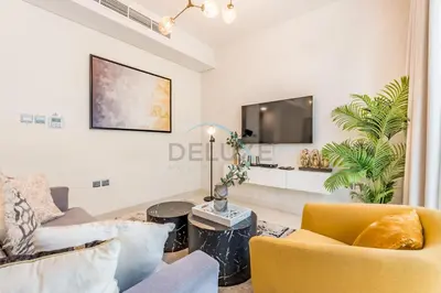 a living room with a couch and a tv at Furnished 3-Bedroom Townhouse, Just Minutes Drive from Al Marmoom Heritage Village and Popular Dubai Attractions, Albizia, Damac Hills 2 by Deluxe Holiday Homes in Dubai