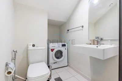 a white bathroom with a washing machine and a sink at Furnished 3-Bedroom Townhouse, Just Minutes Drive from Al Marmoom Heritage Village and Popular Dubai Attractions, Albizia, Damac Hills 2 by Deluxe Holiday Homes in Dubai