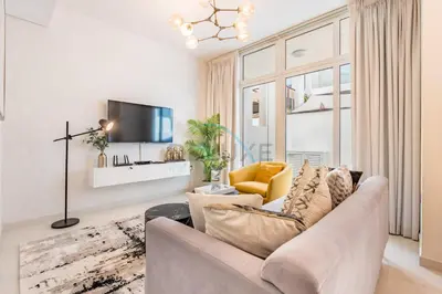 a living room with a couch and a tv at Furnished 3-Bedroom Townhouse, Just Minutes Drive from Al Marmoom Heritage Village and Popular Dubai Attractions, Albizia, Damac Hills 2 by Deluxe Holiday Homes in Dubai