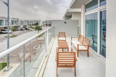 a balcony with chairs and tables on a building at Spell-binding 3BR Townhouse at DAMAC Hills 2 Dubailand by Deluxe Holiday Homes in Dubai