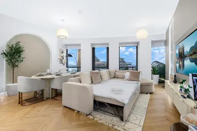 a living room with a white couch and a table at Luxury 2BR with Skyline and Sea Views, Near Burj Khalifa & Dubai Mall in Dubai