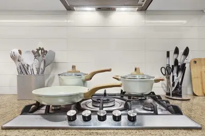 a kitchen stove with two pots and pans on it at Luxury 2BR with Skyline and Sea Views, Near Burj Khalifa & Dubai Mall in Dubai