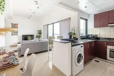 a kitchen and living room with a washer and dryer at Frank Porter - Time Place in Dubai