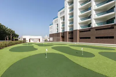 a golf course in front of a building at Taj Exotica Resort & Spa, The Palm, Dubai in Dubai