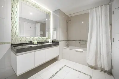 a bathroom with a sink and a tub and a mirror at Stunning 1BR with Partial Sea View in Damac Heights, Dubai Marina-21AB03 in Dubai