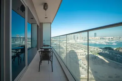 a balcony with tables and chairs and a view of the ocean at Stunning 1BR with Partial Sea View in Damac Heights, Dubai Marina-21AB03 in Dubai