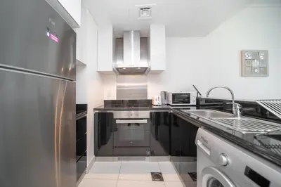 a kitchen with a stainless steel refrigerator and a sink at Stunning 1BR with Partial Sea View in Damac Heights, Dubai Marina-21AB03 in Dubai
