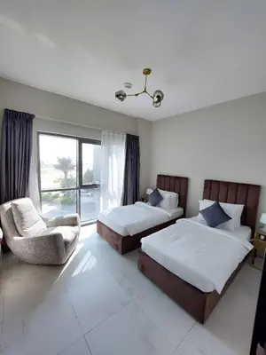 a bedroom with two beds and a chair and a window at Budget-friendly 2bd near EXPO with a huge pool in Dubai