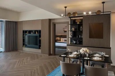 a dining room with a table and chairs and a television at Paramount Hotel Midtown in Dubai