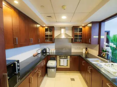 a large kitchen with wooden cabinets and a sink at Luxury 2BR Burj Khalifa Fountain View with Pool, Gym, and Near Dubai Mall in Dubai