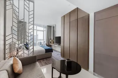 a hotel room with a bed and a table at Luxury Aparthotel Prive in Dubai