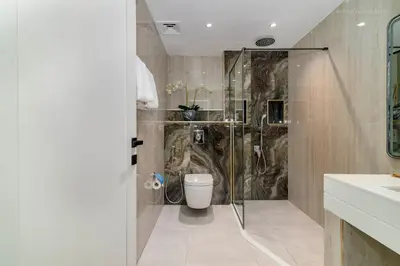 a bathroom with a shower and a toilet at USMANS 4BDRM JBR Sadaf Next to Ritz Carlton Walk Daily Housekeeping JBR in Dubai