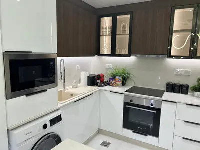 a white kitchen with a sink and a microwave at USMANS 4BDRM JBR Sadaf Next to Ritz Carlton Walk Daily Housekeeping JBR in Dubai