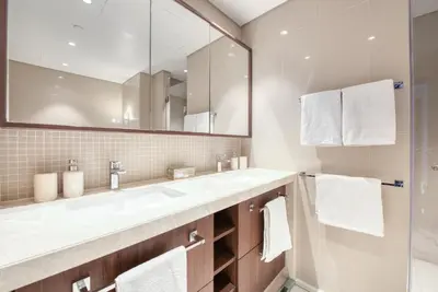 a bathroom with two sinks and a large mirror at Luxurious 3 Bedroom Apartment in Boulevard Point, Connected to Dubai Mall in Dubai