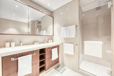 a bathroom with a shower and a large mirror at Luxurious 3 Bedroom Apartment in Boulevard Point, Connected to Dubai Mall in Dubai