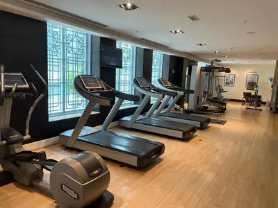 a gym with a row of treadmills and machines at Walk to Burj Khalifa from this 2BR with Skyline Balcony View in Dubai