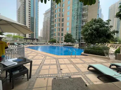 a swimming pool in a city with tall buildings at Walk to Burj Khalifa from this 2BR with Skyline Balcony View in Dubai