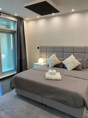 a bedroom with a large bed with two towels at Luxury 2BR Walk to Burj Khalifa and Dubai Mall with Pool and Gym in Dubai