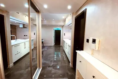 a large kitchen with white cabinets and a glass doorway at Luxury 2BR Walk to Burj Khalifa and Dubai Mall with Pool and Gym in Dubai