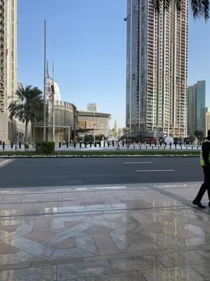 a person walking down a street in a city at Luxury 2BR Walk to Burj Khalifa and Dubai Mall with Pool and Gym in Dubai