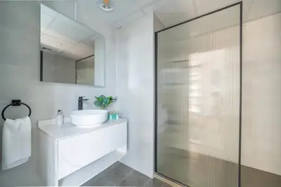 a bathroom with a glass shower and a sink at Frank Porter - Yacht Bay in Dubai