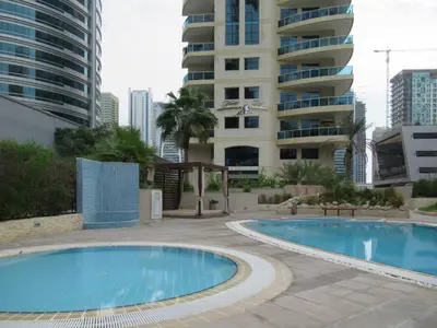 a swimming pool in front of a tall building at Frank Porter - Yacht Bay in Dubai