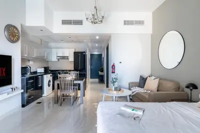 a room with a bed and a living room with a kitchen at GuestReady Holiday Homes - On The Rocks in Dubai