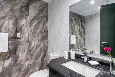 a bathroom with a sink and a large mirror at GuestReady Holiday Homes - On The Rocks in Dubai