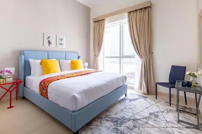 a bedroom with a blue bed with yellow pillows at Frank Porter - Mon Reve in Dubai