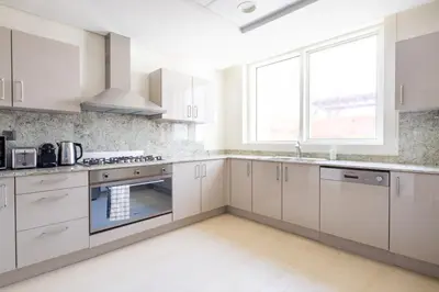 a white kitchen with white cabinets and a window at Frank Porter - Mon Reve in Dubai