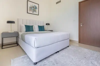 a white bedroom with a large white bed and a table at Frank Porter - 5242 EMAAR Tower in Dubai