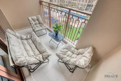 an overhead view of a balcony with two chairs and a table at Exquisite 2BR at Zahra Breeze Dubailand by Deluxe Holiday Homes in Dubai