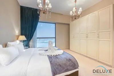 a bedroom with a large bed and a large window at High-floor 1BR Unit Close to Beach with Sea Views, Sadaf 6, Jumeirah Beach Residence by Deluxe Holiday Homes in Dubai