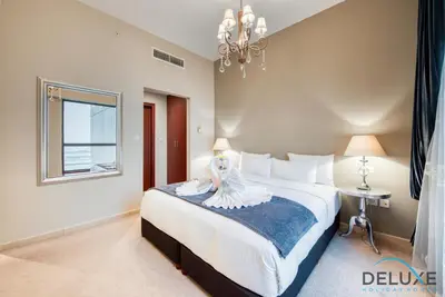 a bedroom with a large bed with a dress on it at High-floor 1BR Unit Close to Beach with Sea Views, Sadaf 6, Jumeirah Beach Residence by Deluxe Holiday Homes in Dubai