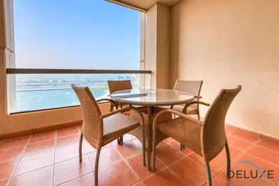 a dining room with a table and chairs and a window at High-floor 1BR Unit Close to Beach with Sea Views, Sadaf 6, Jumeirah Beach Residence by Deluxe Holiday Homes in Dubai