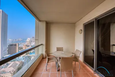 a dining room with a table and chairs on a balcony at High-floor 1BR Unit Close to Beach with Sea Views, Sadaf 6, Jumeirah Beach Residence by Deluxe Holiday Homes in Dubai