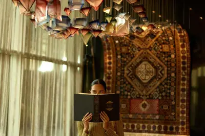 a woman reading a book in front of a mirror at W Dubai - Mina Seyahi in Dubai